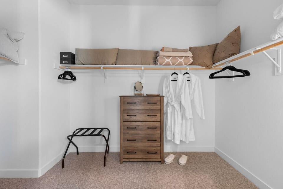 Walk-in closet w/ dresser, hanging space & plush robes ready for you