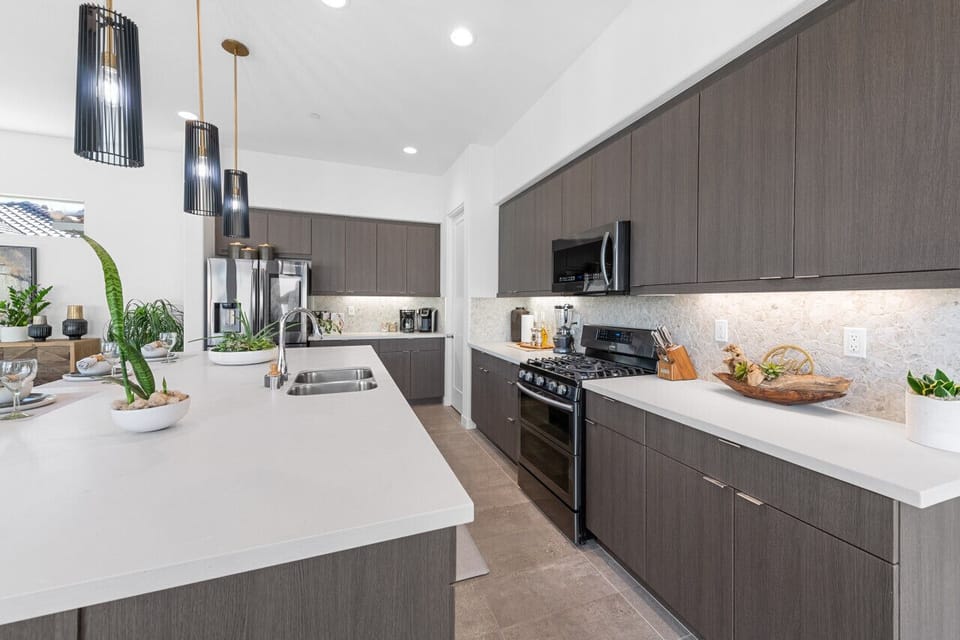 Designer kitchen w/ large island, stainless steel appliances & ample counter space