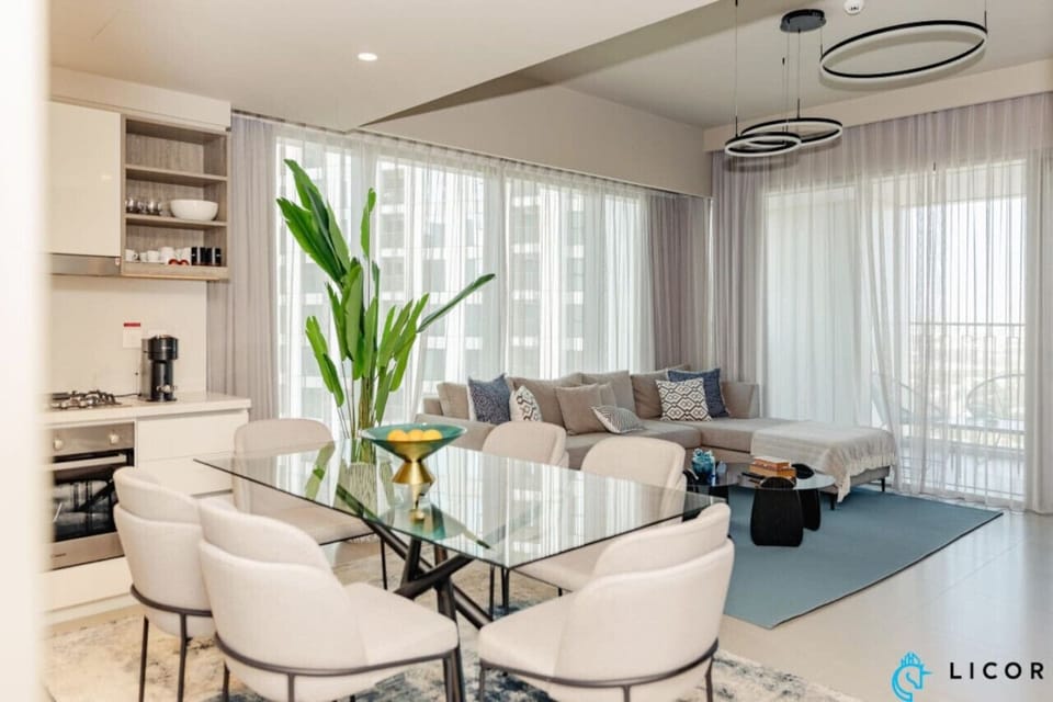 Spacious open-plan living room and dining area with floor-to-ceiling windows offering stunning city views.