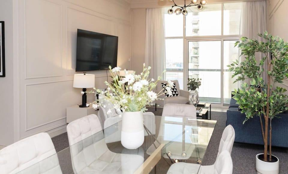 Gather around the glass-top dining table, perfect for shared meals or work sessions, with a stunning view to set the scene.