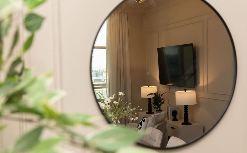 A stylish mirror captures the essence of the living room, with elegant lighting and comfortable seating creating a cozy ambiance.