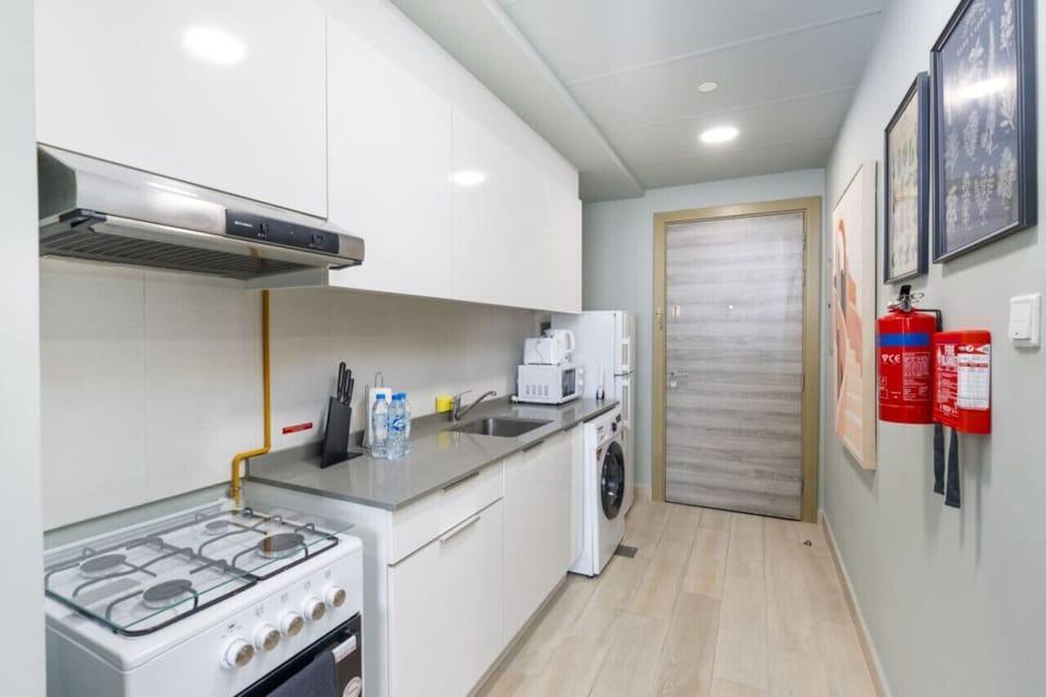 The kitchenette is equipped with all the essentials for preparing meals, including a stove, microwave, and refrigerator.