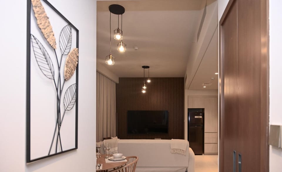 This well-lit hallway provides a warm and inviting ambiance, connecting the different spaces in the apartment with style.