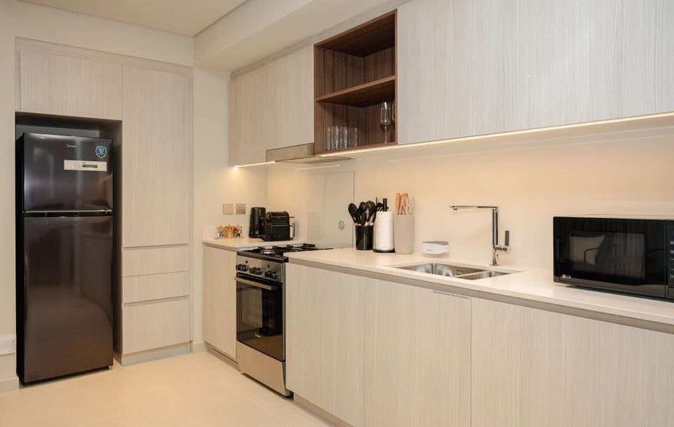 Cook your favorite meals in this fully equipped kitchen featuring modern appliances, sleek cabinetry, and ample counter space.