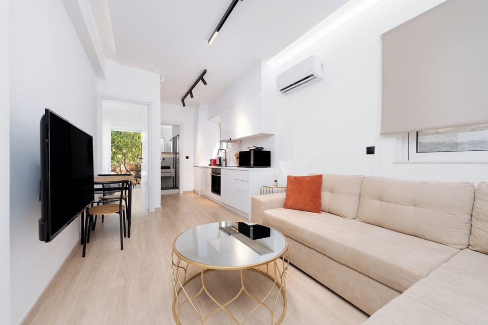 Deluxe Apartment, 1 Bedroom, Patio, Garden View | Living area | 50-inch TV with cable channels
