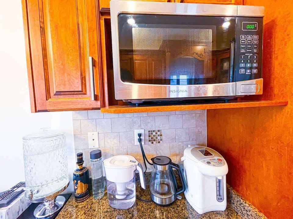 Well-equipped kitchen corner with a microwave, coffee maker, and hot water dispenser for all your beverage needs.