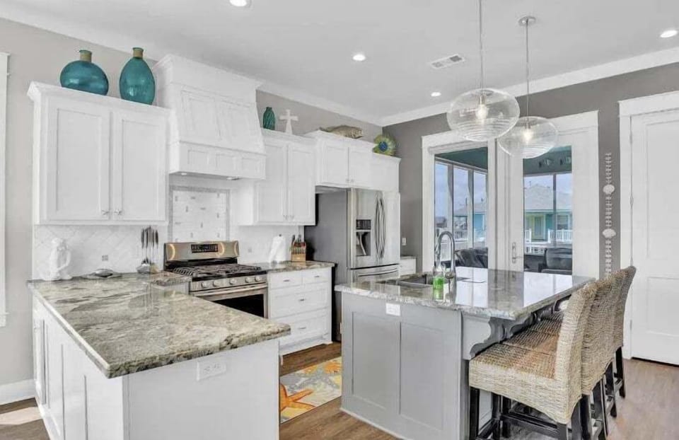 Modern kitchen with white cabinetry, stainless appliances, and bar seating