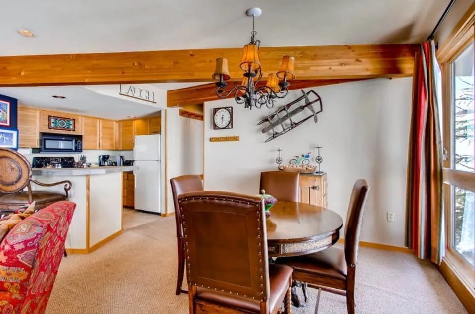 Combining elegance with comfort, the dining nook showcases a charming chandelier and is positioned to take advantage of the stunning outdoor scenery through large glass doors.