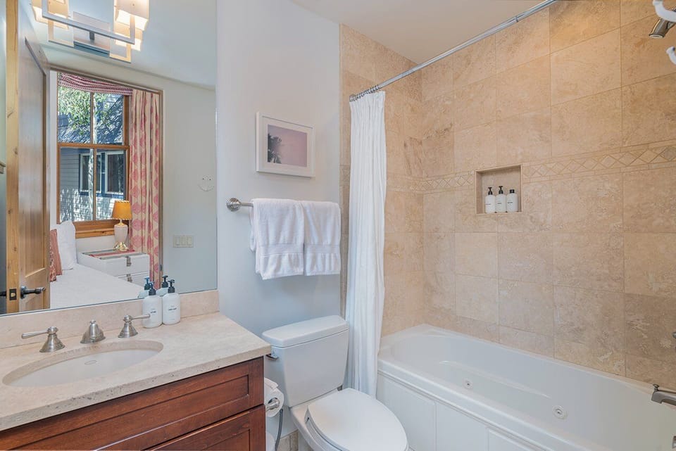 The ensuite bathroom features a tub/shower combo and a single vanity.
