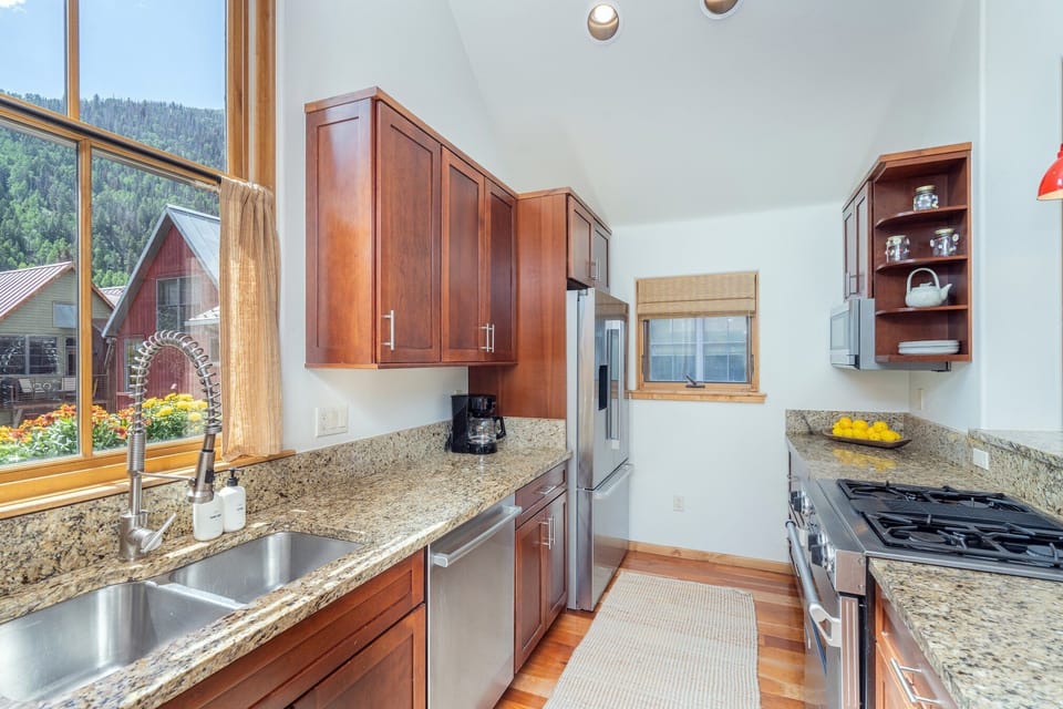 This spacious kitchen offers ample room for cooking, featuring top-of-the-line stainless steel appliances, a gas stove, and a full walk-in pantry for added convenience.