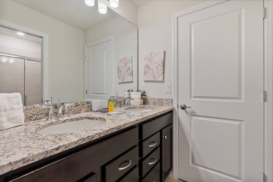 Welcome to this bright bathroom with a spacious granite countertop, perfect for your essentials. Soft lighting enhances the elegant decor, and modern fixtures add clean lines, creating a refreshing atmosphere for your comfort.