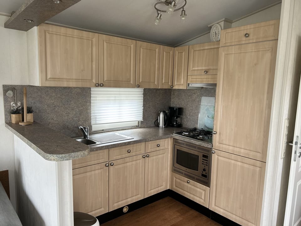 Kitchen with oven, gas stove, refrigerator and kettle