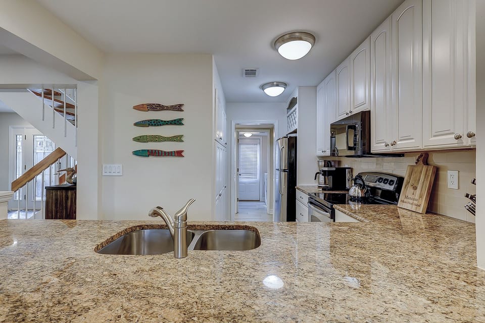 Fully stocked kitchen with stainless steel appliances.