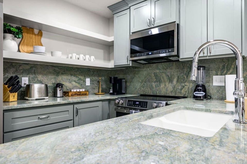 This kitchen features open shelving with dishes and all of your essential items for your stay