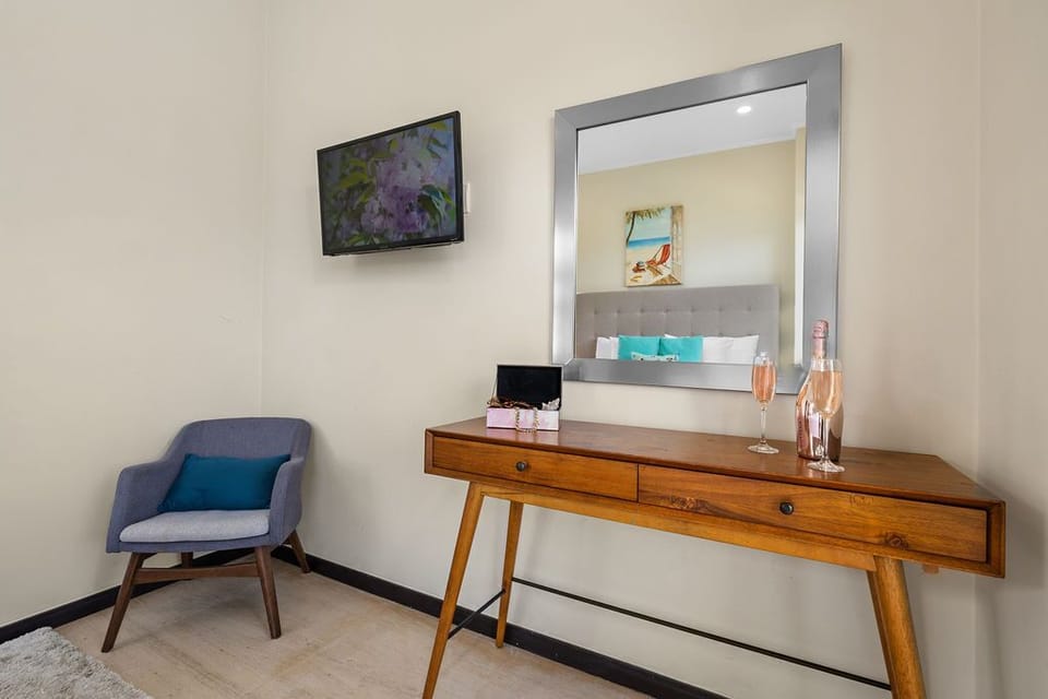 Elevate your stay in our charming sitting area. The elegant vanity cabinet and mirror add a touch of sophistication to your space.
