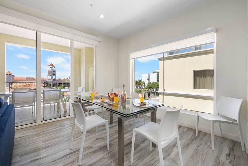 Featuring a sleek glass table with comfortable seating for four, the space is perfect for intimate meals or casual gatherings.