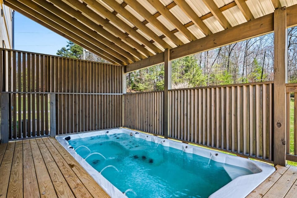 The swim spa is located on the lower level deck and includes a privacy fence around the outside.