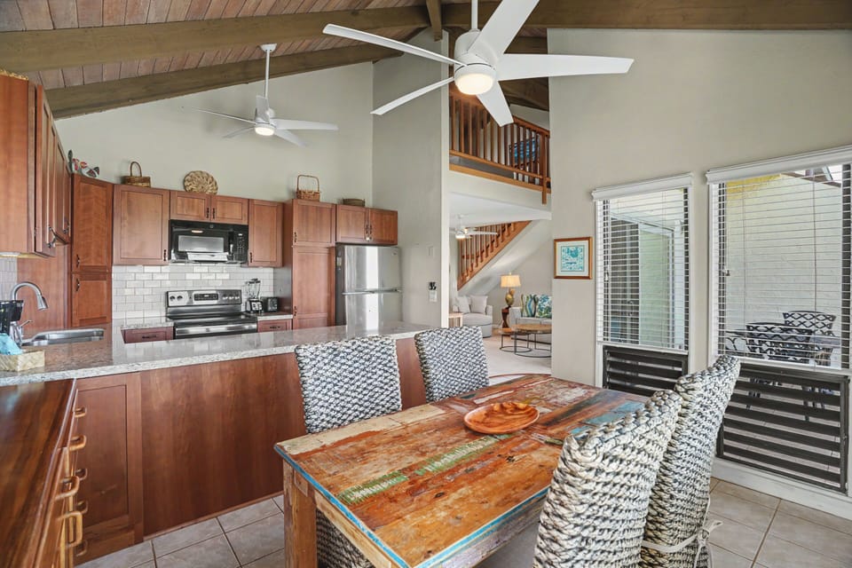 Gather around the rustic dining table in this airy open-concept space, where cathedral ceilings and ceiling fans keep you cool while you enjoy home-cooked meals from the fully equipped kitchen.