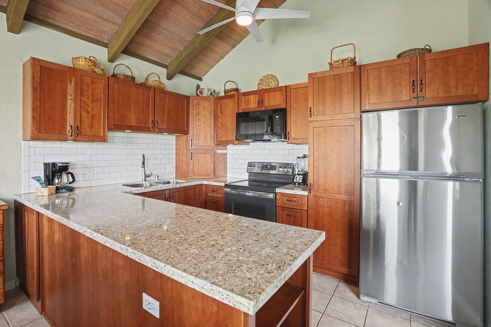 Your fully-equipped kitchen features warm wood cabinetry, gleaming granite counters, and stainless steel appliances—perfect for preparing home-cooked meals during your stay.