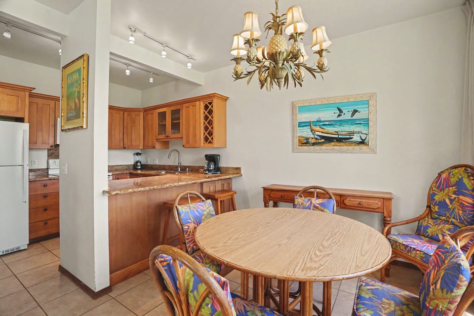 Gather around your dining table, where a tropical chandelier and coastal artwork set the tone for relaxed island meals with loved ones.