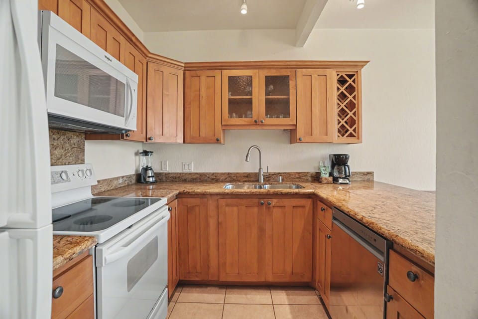 Your fully equipped kitchen features rich wood cabinetry, granite countertops, and modern appliances—perfect for preparing meals at home or brewing morning coffee before exploring the area.