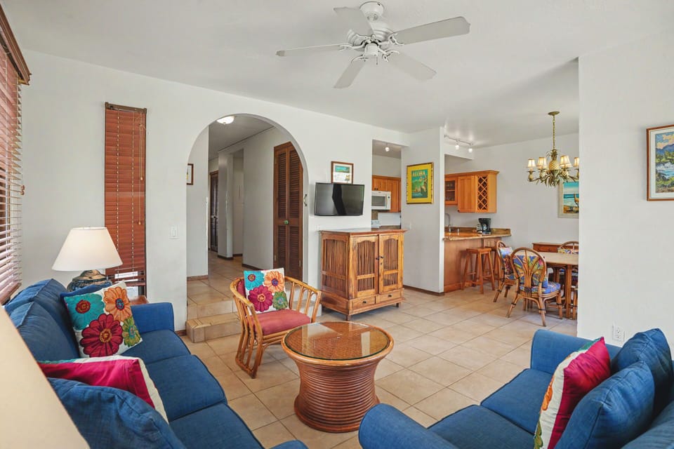 Settle into this bright, open living space with vibrant island charm. Relax on the plush blue sofas, enjoy your favorite shows, and feel the ceiling fan's gentle breeze.