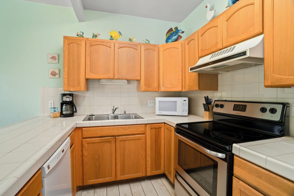 Step into your fully equipped kitchen with everything you need to prepare memorable meals: full-size appliances, tile countertops, and cheerful tropical touches that make cooking feel like a breeze.