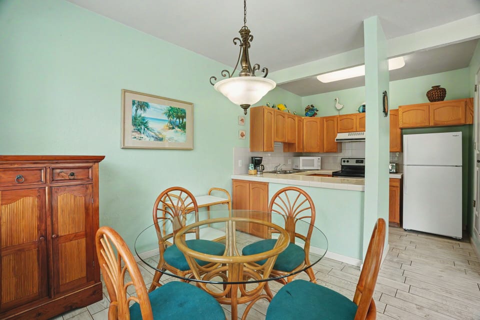 Picture yourself settling in at this inviting dining table, where shared meals become cherished memories. The fully equipped kitchen stands ready for your favorite recipes, while the coastal décor sets a relaxing tone throughout.