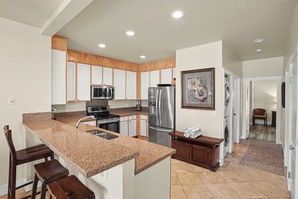 Your fully equipped kitchen features granite countertops, stainless steel appliances, and an open layout perfect for preparing meals together during your stay.