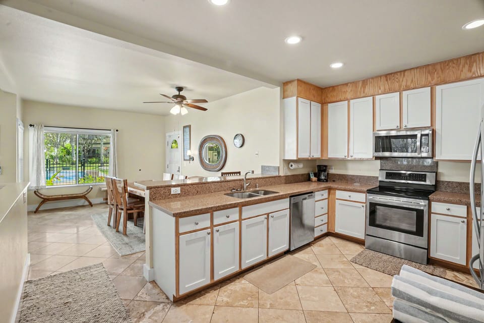 Your fully equipped kitchen awaits, with granite countertops, stainless steel appliances, and views of the sparkling pool just outside—perfect for preparing meals in a space that feels like home.