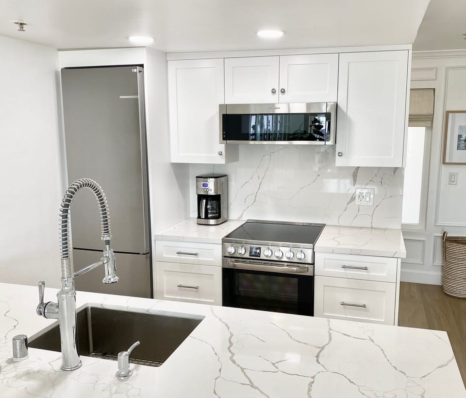 New stainless steel appliances, built-in Bosch refrigerator, quartz backsplash.