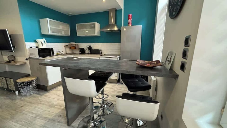 Cuisine équipée avec four, plaques de cuisson, bouilloire, machine à café, micro-ondes, grille-pain et réfrigérateur avec congélateur.
Coin repas pour quatre personnes.
La cuisine est ouverte sur le salon.