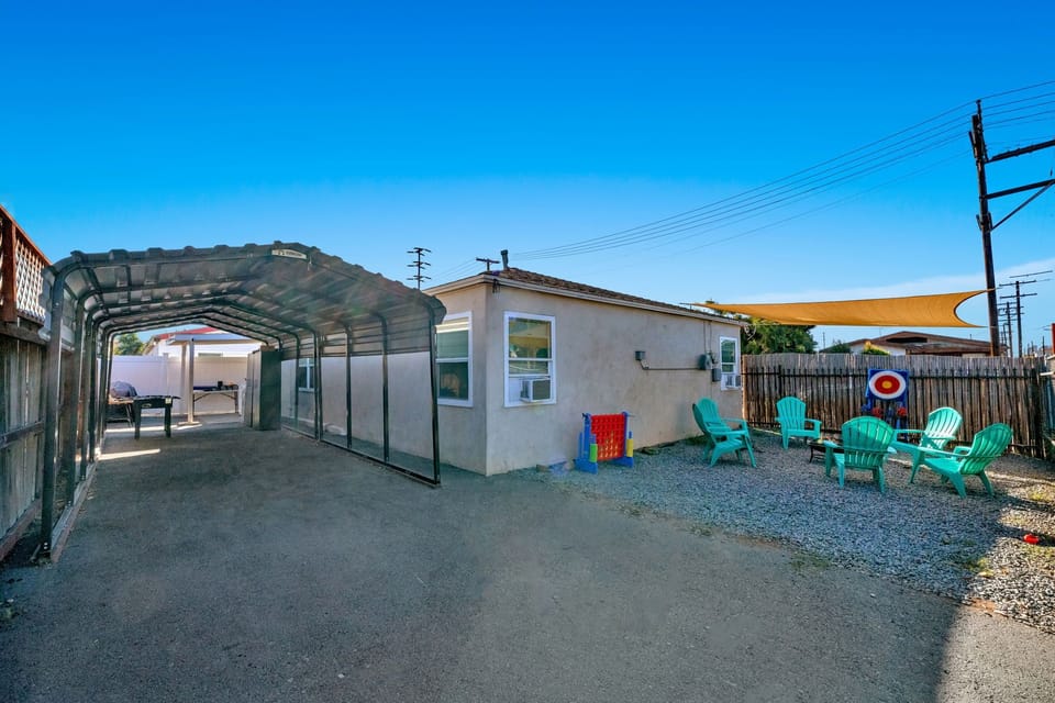 A vibrant backyard with comfy furniture, BBQ grill, fire pit, and outdoor games.