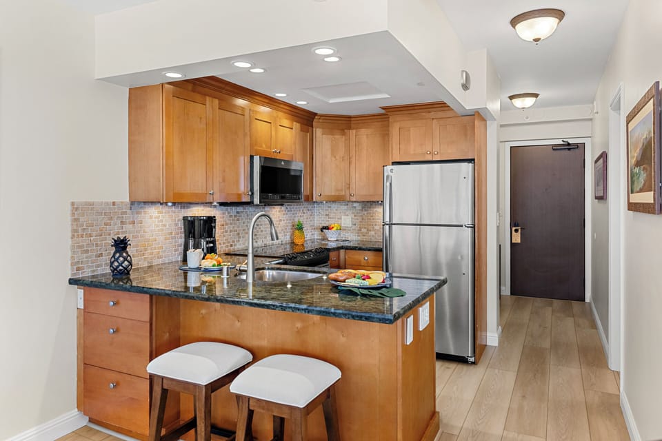 Your gourmet kitchen awaits with granite counters, stainless appliances, and a breakfast bar perfect for morning coffee or evening wine.