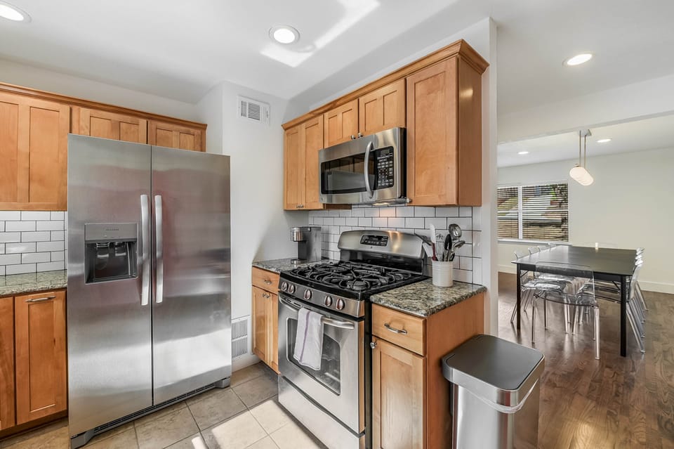 Gas range and a variety of pots, pans, baking sheets and cooking utensils.