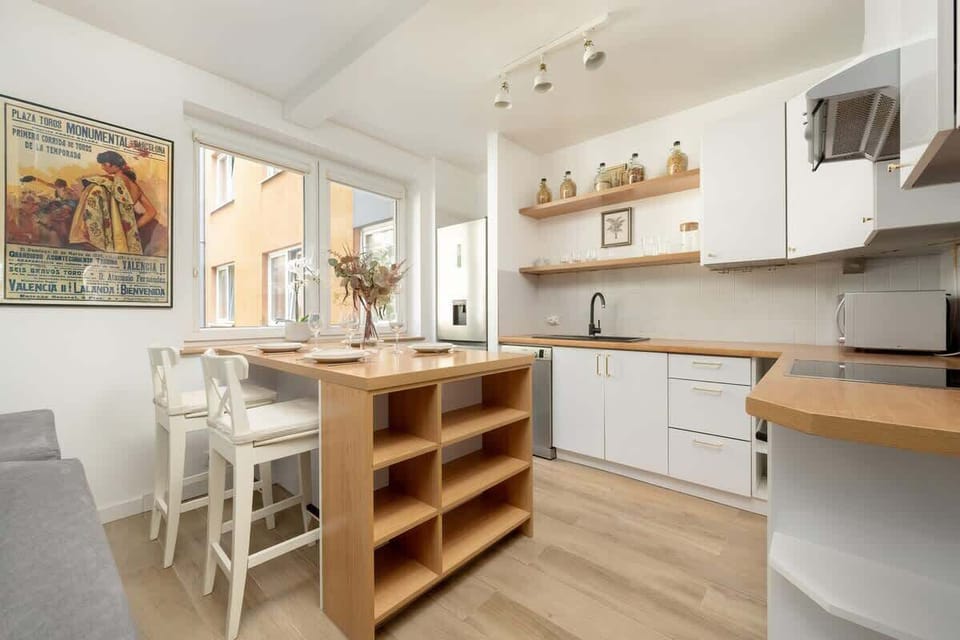 Kitchenette with an electric stove, oven, dishwasher, steam absorber, capsule coffee maker, refrigerator, freezer, electric kettle and microwave.
