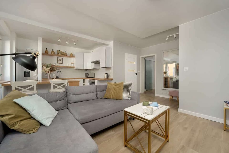 Living room with a comfortable sofa bed and TV. Kitchenette in the background.