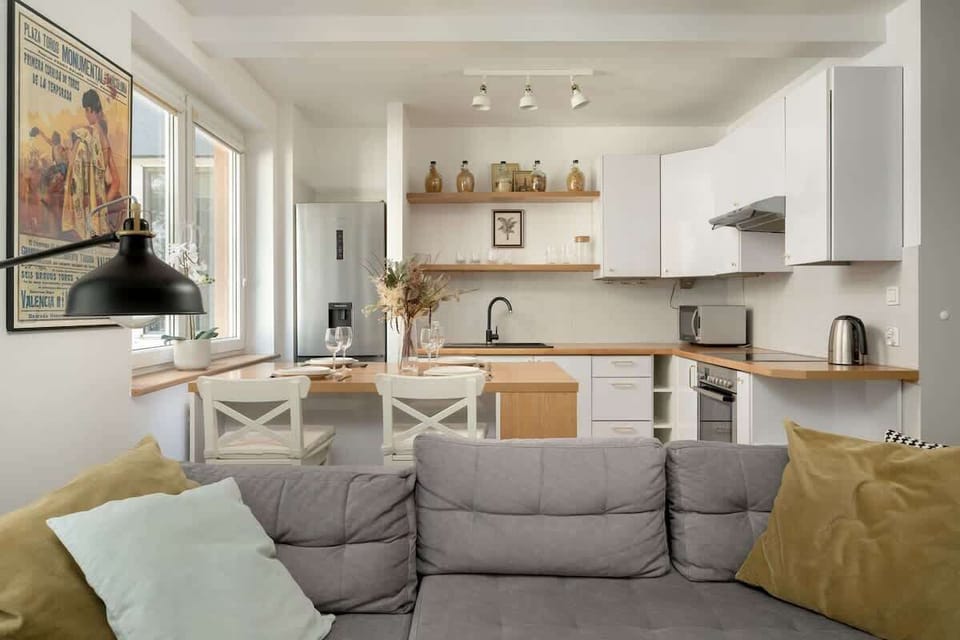 Living room with fully equipped kitchenette and dining area.