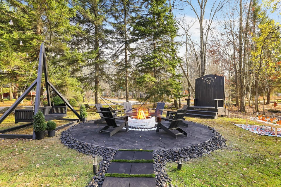 A cozy fire pit sits nearby, encircled by inviting Adirondack chairs.
