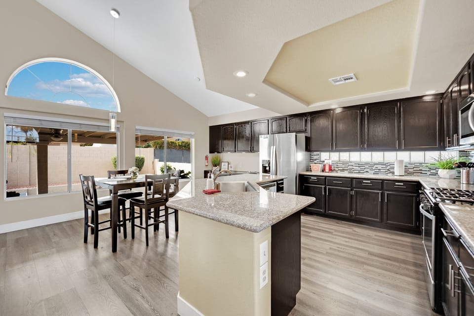 The enormous kitchen boasts an informal dining area with extra cabinets, updated fixtures, modernized cabinetry, and sleek countertops. It's fully stocked with everything you need to prepare home-cooked meals.