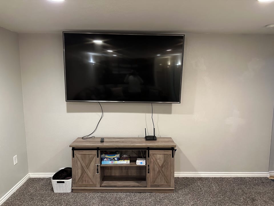 Basement living area with 75" Smart TV.