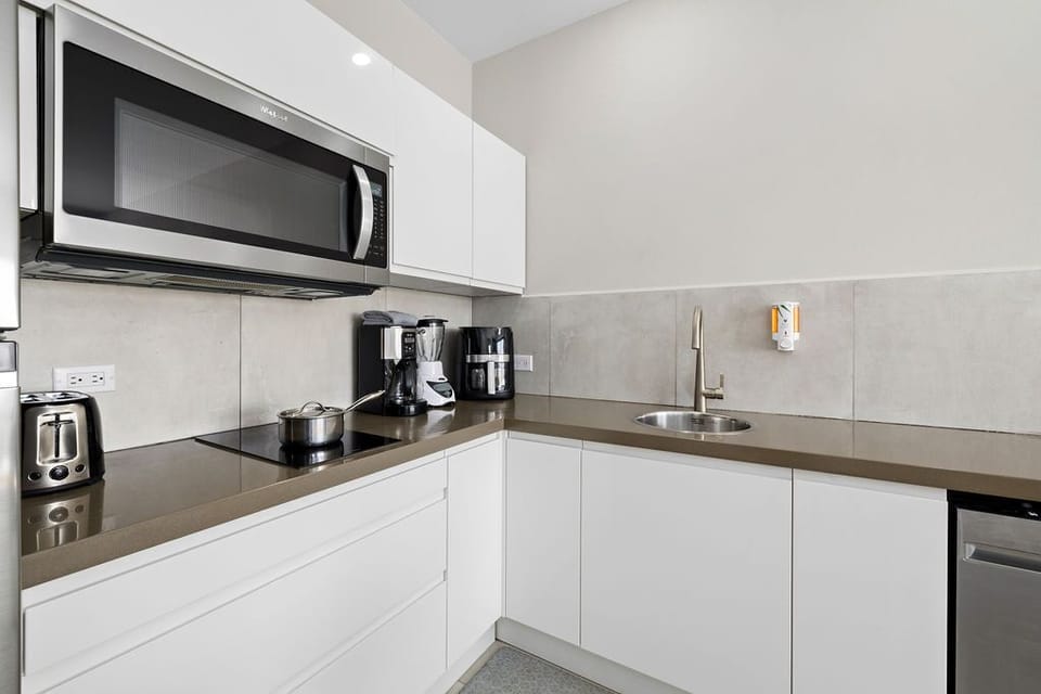 Kitchen area with microwave, refrigerator, oven, and sink.