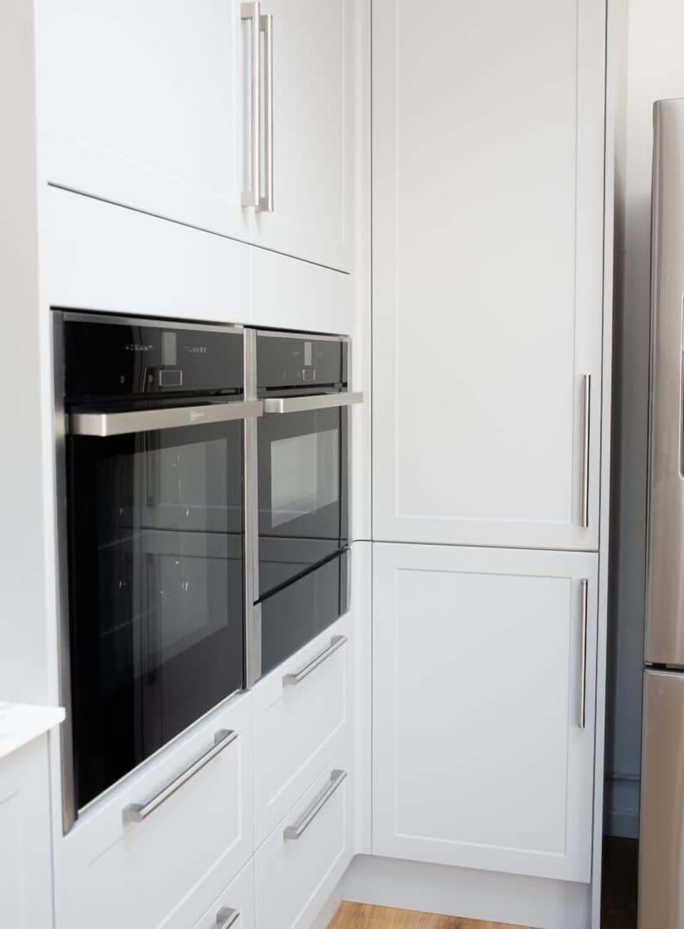 A well-organized kitchen showcasing a sleek oven and neatly arranged kitchen drawers, combining functionality with a modern aesthetic.