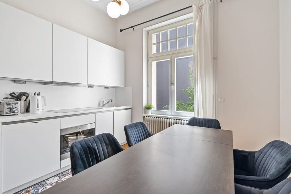 Bright and modern kitchen with a sleek dining area, perfect for enjoying meals with a view of the garden.