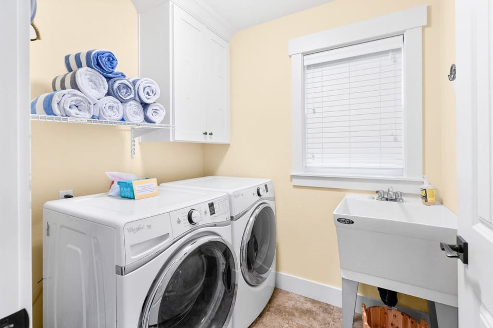 Laundry room — washer, dryer, and a utility sink for beach gear