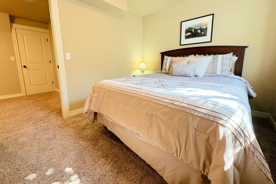 Bedroom #4, located in the basement, has a queen bed and great natural light through the window well.