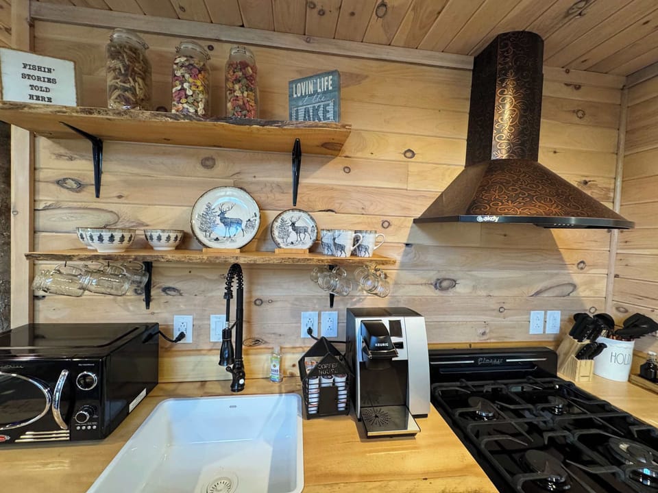 Rustic charm meets modern convenience — everything you need is right here, from your morning coffee to evening meals, surrounded by warm wood tones and thoughtful cabin touches.
