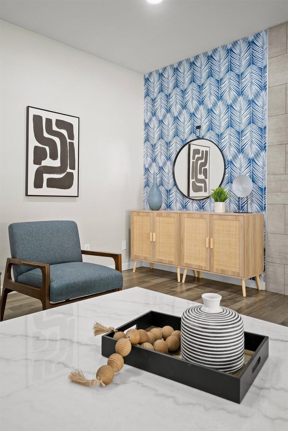 A stylish wooden cabinet and round mirror in the other corner