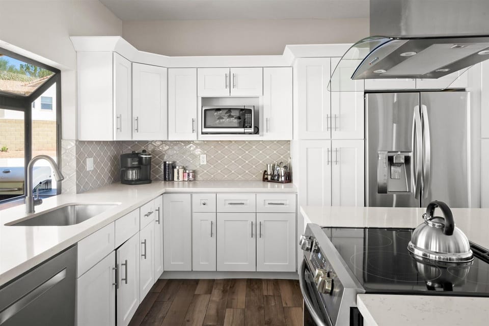 Featuring high-end stainless steel appliances, tons of white cabinetry, and a spacious island for all your culinary adventures