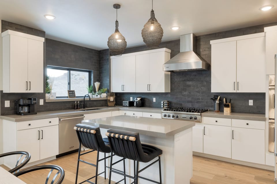 Kitchen features an island with barstool seating.